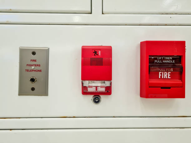 set of fire extinguishers on the hospital wall. alarms, telephones, and fire-fighting trigger levers